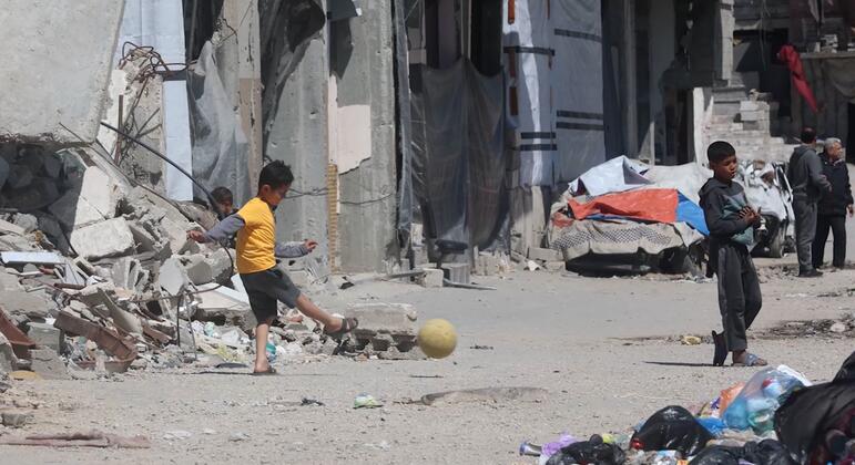 Children play football amidst the rubble of Gaza City..
